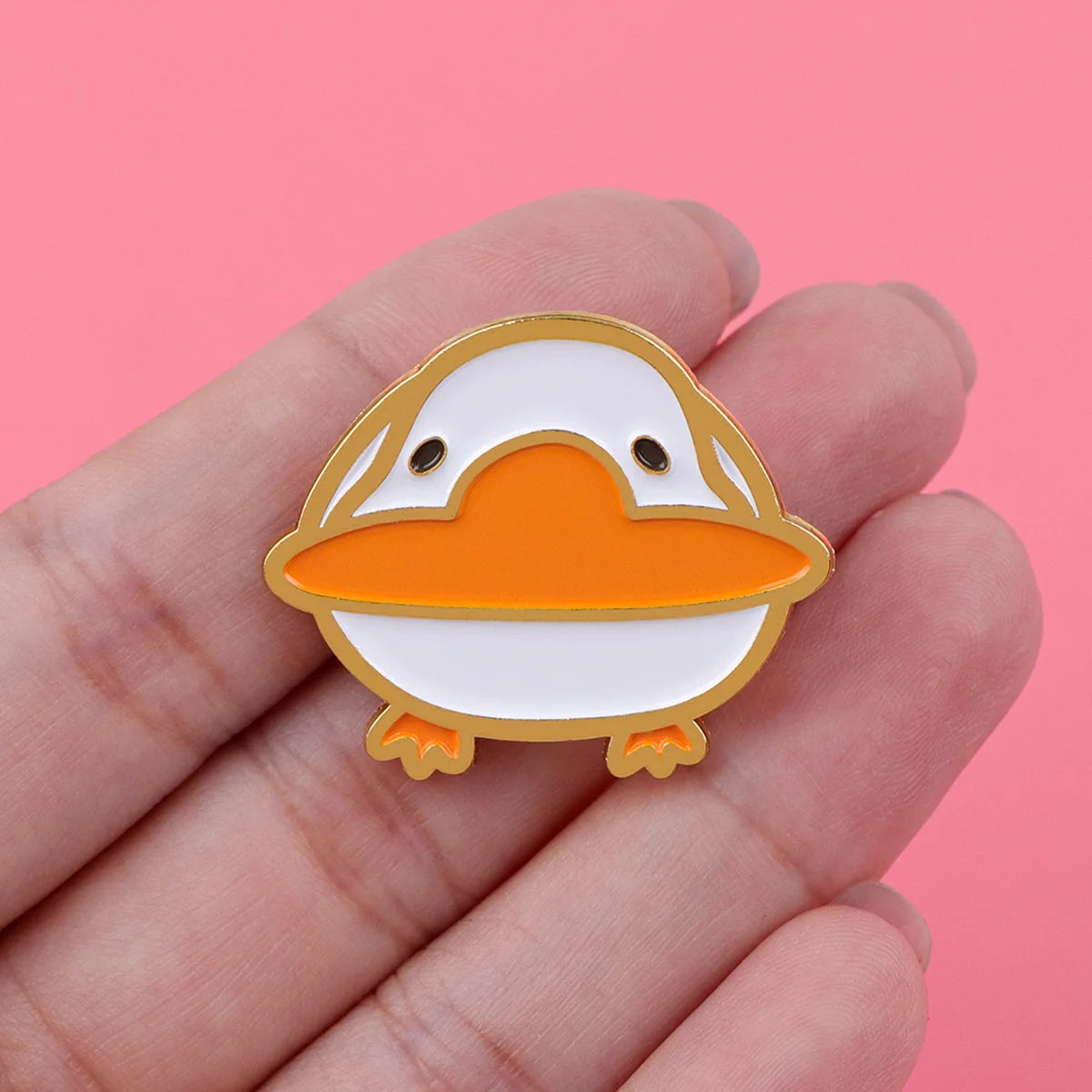 Orange and white penguin enamel pin with small feet