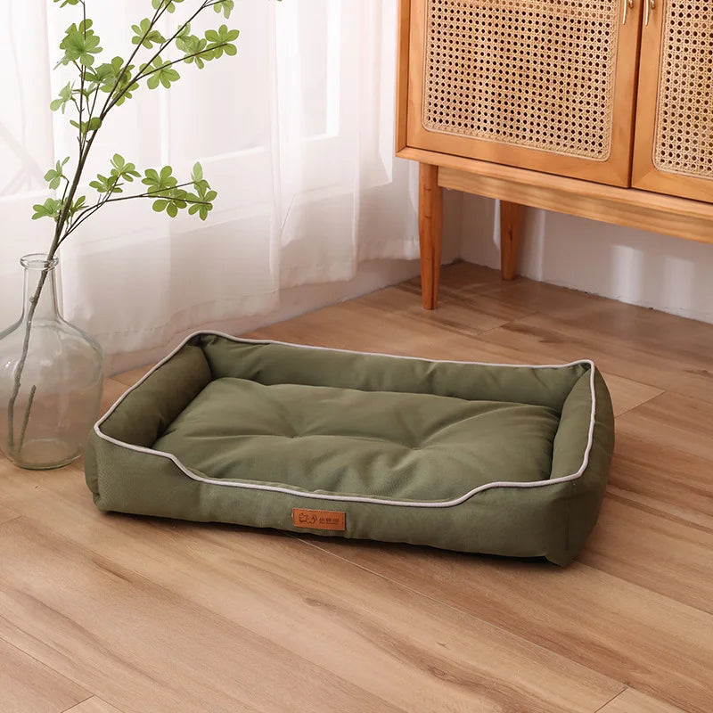 Olive green plush pet sofa bed with white piping and raised edge bolsters