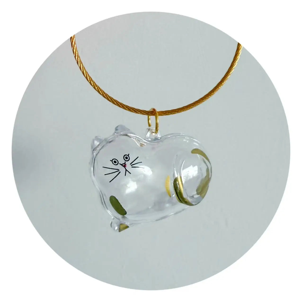 Clear resin cat charm with green paw details and a gold cord loop