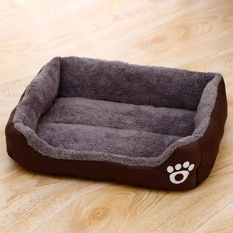 Plush dog bed with gray inner lining and brown outer base, paw logo on side