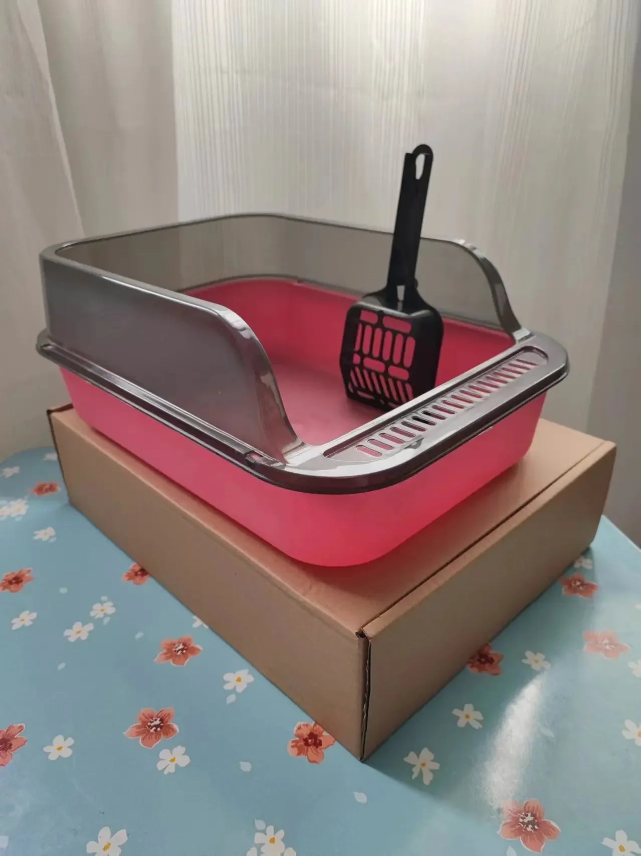 Pink semi-enclosed cat litter box with black scoop and rake tray
