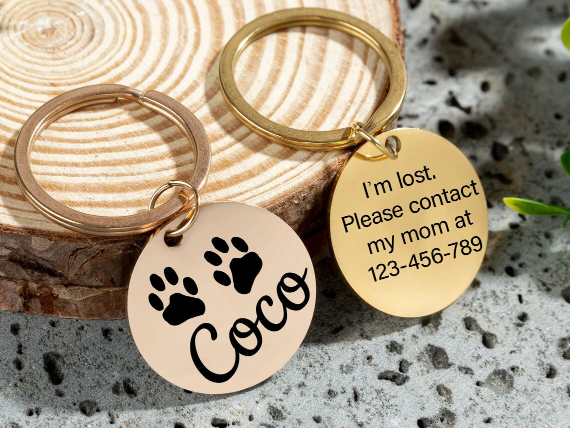 Two gold pet ID tags with paw prints, Coco name, and lost contact text on keyrings