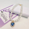 Adjustable pearl pet collar with blue heart charm and gold-tone clasp