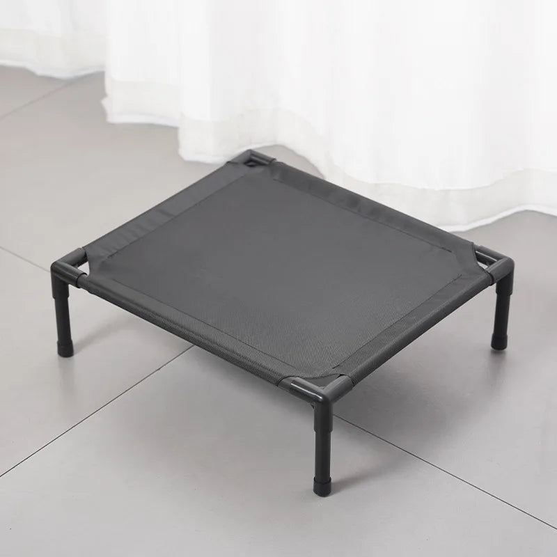 Outdoor elevated dog cot with dark gray fabric cover and black metal legs