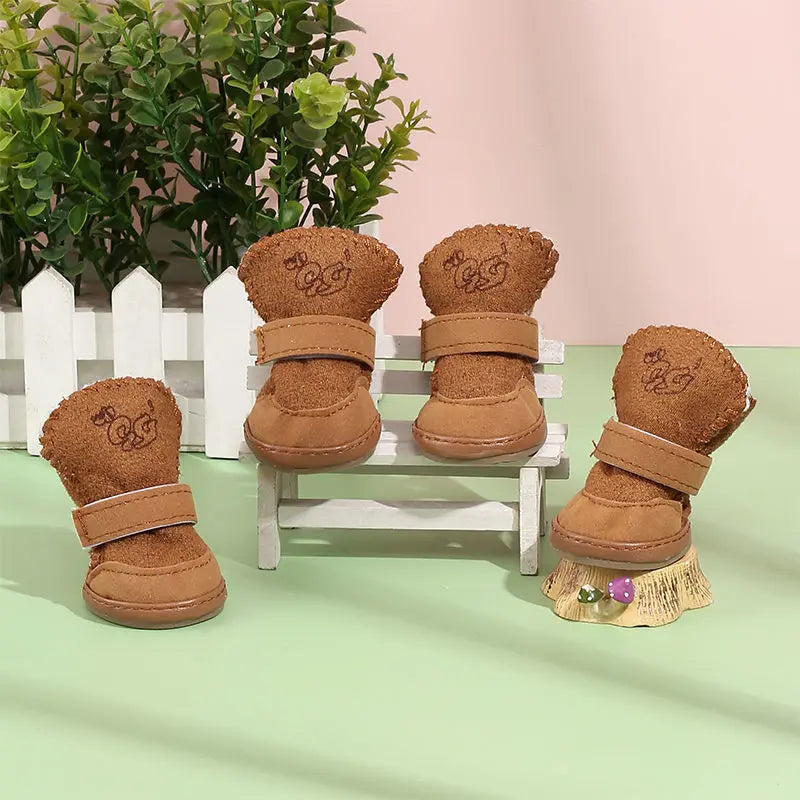 Brown pet snow boots on bench with plush paw-printed cuffs and hook straps