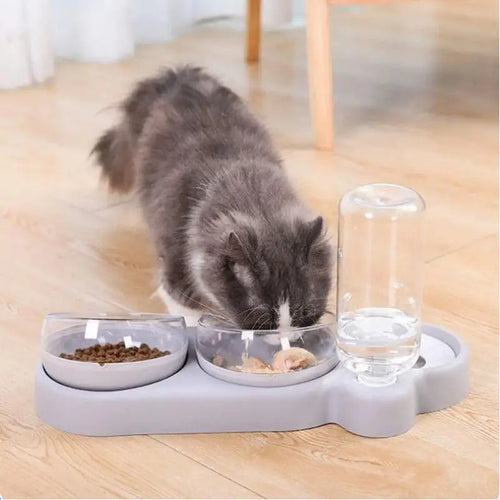 Three-bowl automatic pet feeder with clear water tube and two food bowls, white base with cat.