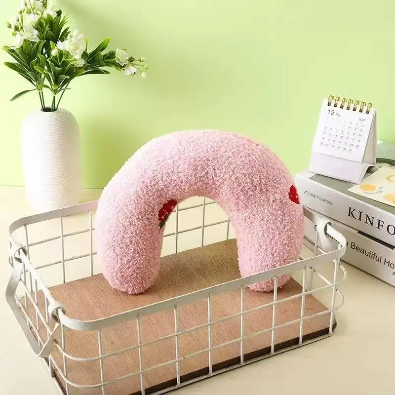Pink U-shaped plush pet pillow with red strawberry appliques