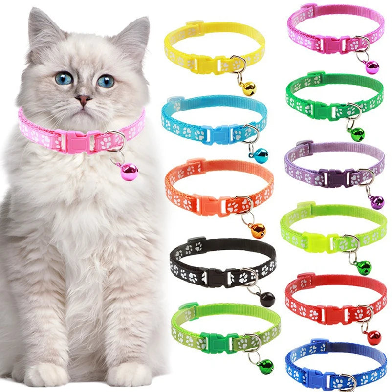 Cat collar with paw print bow and bell, worn on a light gray cat