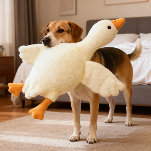 White soft goose plush toy with orange beak and feet, held across dog's chest
